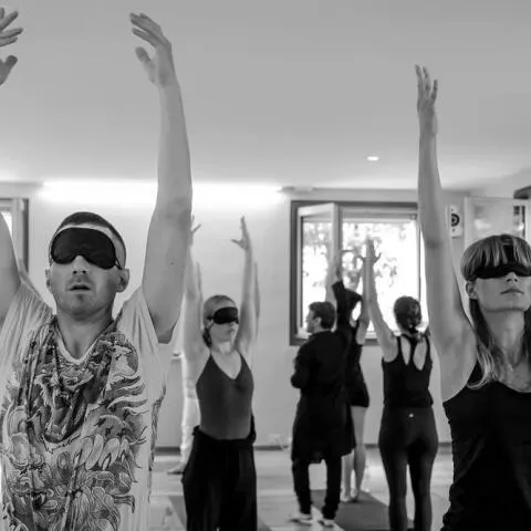A close-up portrait of a man with graying hair and glasses smiling