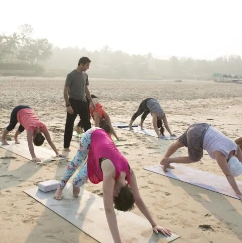 A group of people practicing yoga on beach