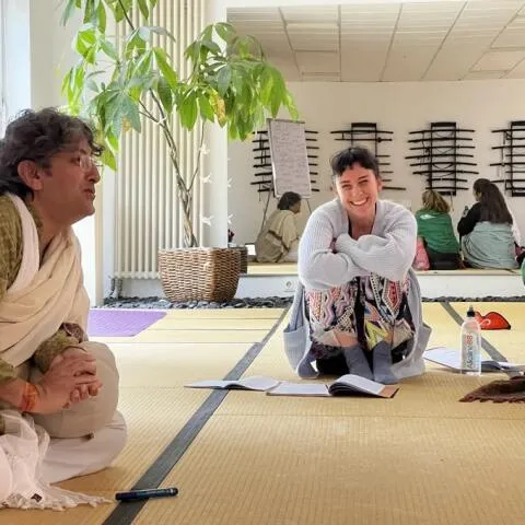 A man and a woman sitting and talking during a workshop with notebooks