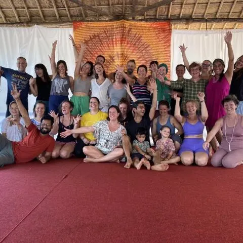 A large, joyful group of people of various ages posing together
