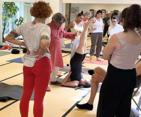 Yoga teacher instructing shoulder stand