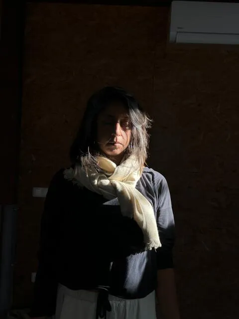 Woman standing with eyes closed in mindful meditation under dramatic natural light.